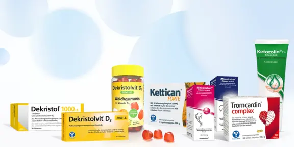 Eine Auswahl an Medikamentenschachteln, eine Flasche Vitamingummis und eine Tube Creme, angeordnet auf einem weißen Hintergrund mit blauen Kreisen.